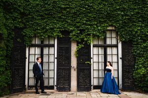 Ivy-covered brick wall creates a romantic backdrop for a wedding photo shoot.