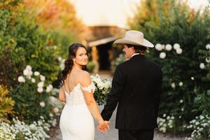Elegant outdoor garden wedding ceremony with white floral arrangements and natural greenery backdrop.