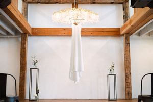 A modern rustic interior space with exposed wooden beams, pendant lighting, and white walls creating an airy atmosphere.