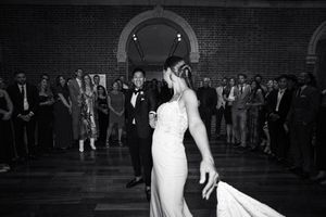 Black and white reception dance floor scene with guests celebrating.