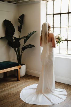 A series of minimalist bridal portraits showing a flowing white wedding dress against a bright studio with hardwood floors.