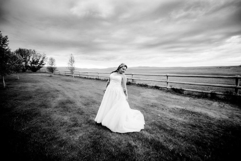 Bride in wedding gown twirling in field in black and white in Dickson, TN