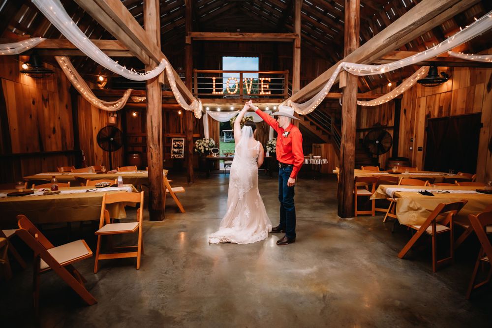 Groom spins bride around in reception area in the barn at Cactus Creek in Dickson, TN