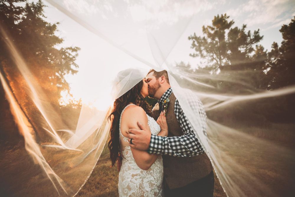 Bride and groom kiss under the bride's veil at sunset in Dickson, TN