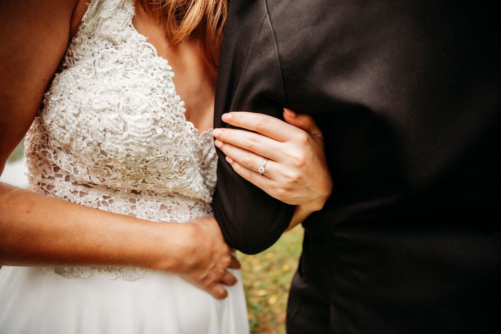 Bride in her wedding gown showing her wedding ring against her husbands arm in Dickson, TN
