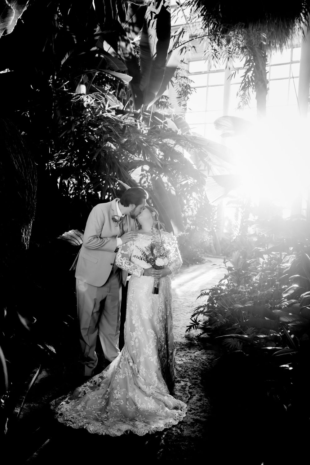Bride and groom together among trees and plants in black and white in Dickson, TN
