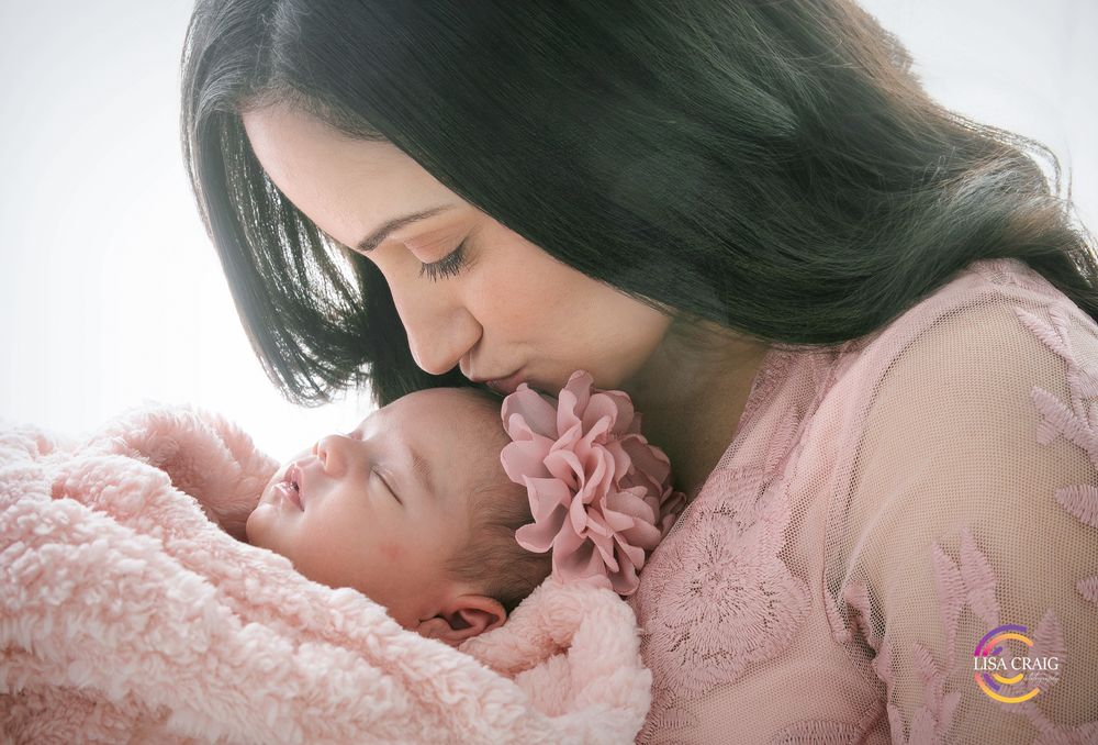 A collection of intimate moments showing a parent kissing and bonding with a sleeping baby in soft pink tones.