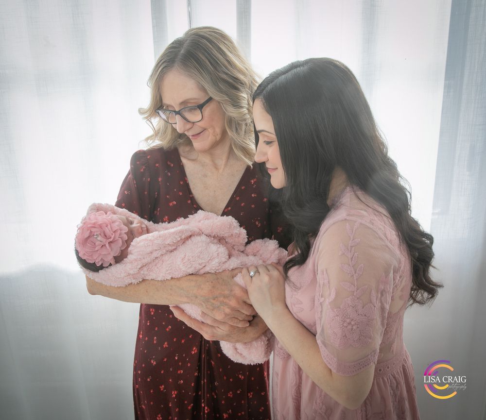 A tender bonding moment as a mother gently kisses her baby's forehead in a softly lit nursery.
