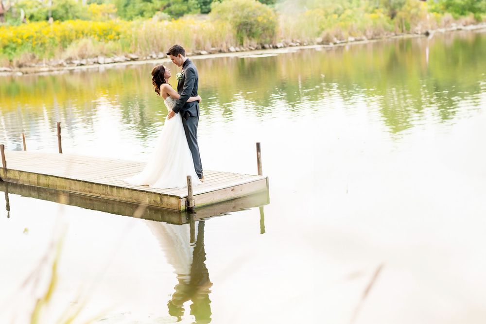 Couple poses for romantic photos on a wooden dock by a serene lake at Springwater Conservation Area.