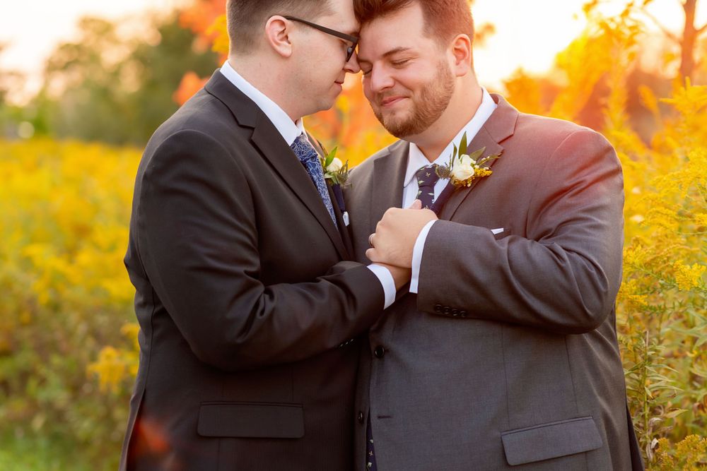 Wedding couple embraces during golden hour in an autumn field in Waterloo behind Canadian Clay & Glass Gallery.