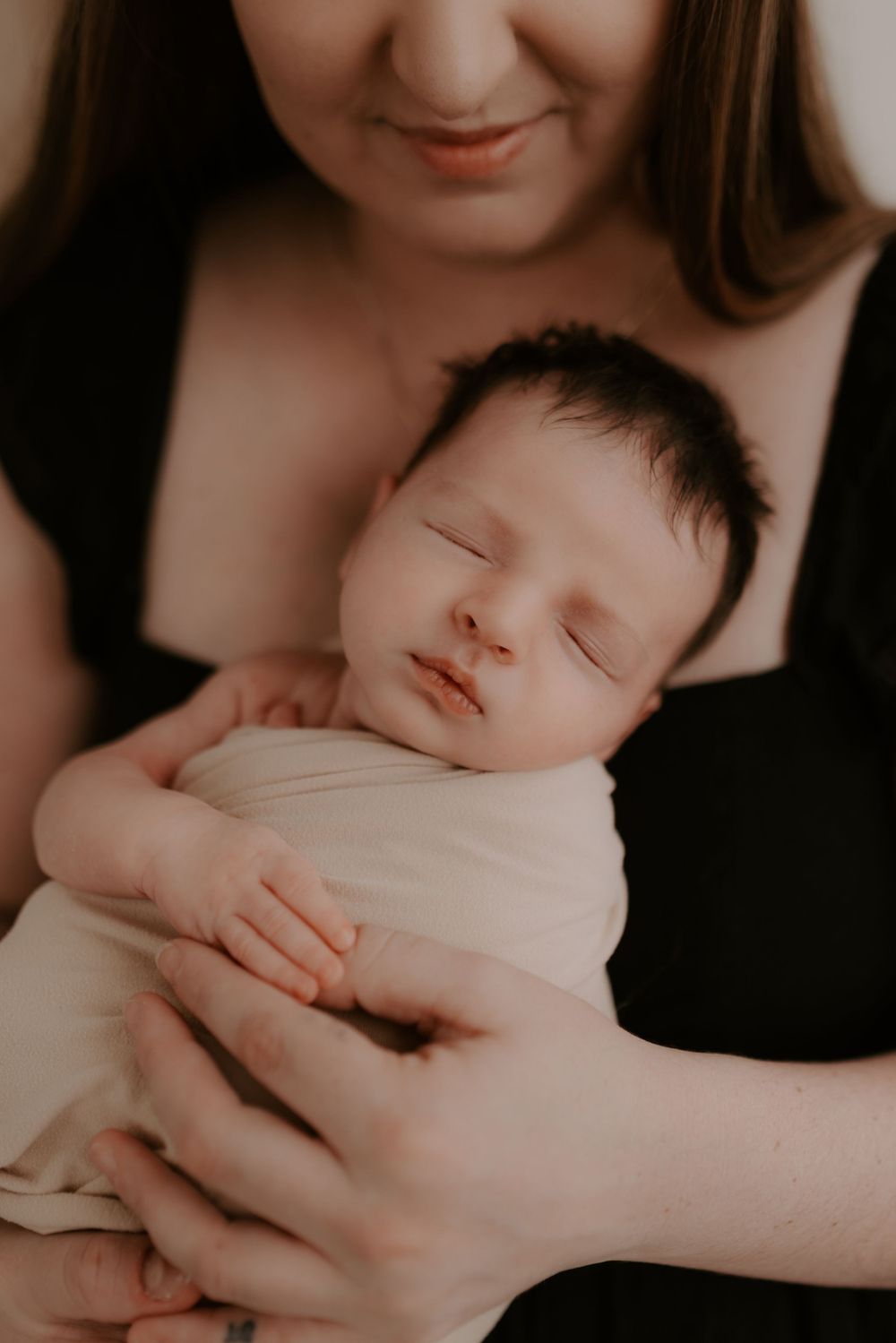 Artistic black and white series capturing gentle moments with sleeping infant.