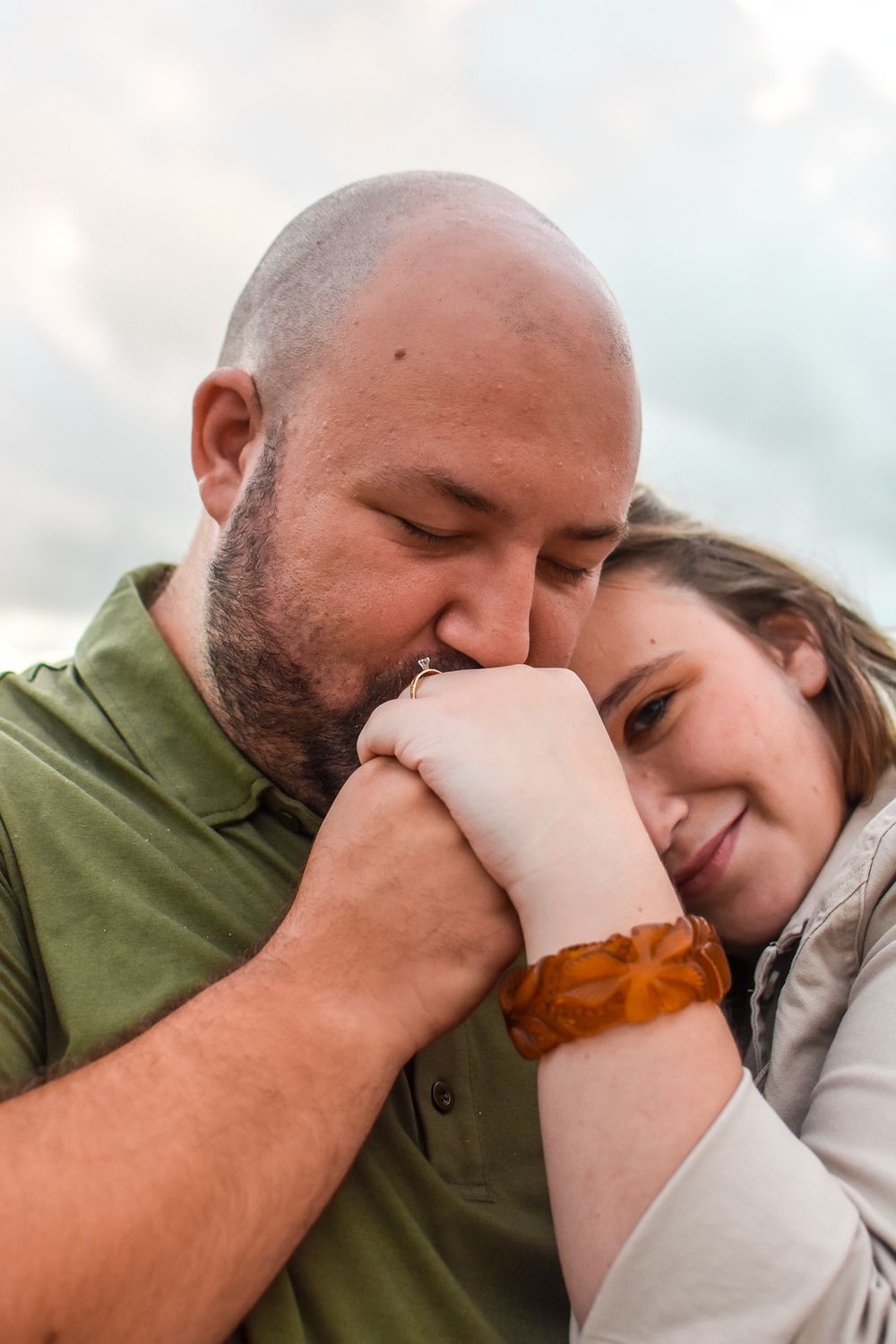 A tender moment shared between a couple embracing outdoors with soft lighting and warm expressions.