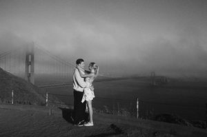 Newly engaged couple celebrating their San Francisco proposal near the Golden Gate Bridge with timeless film photography.