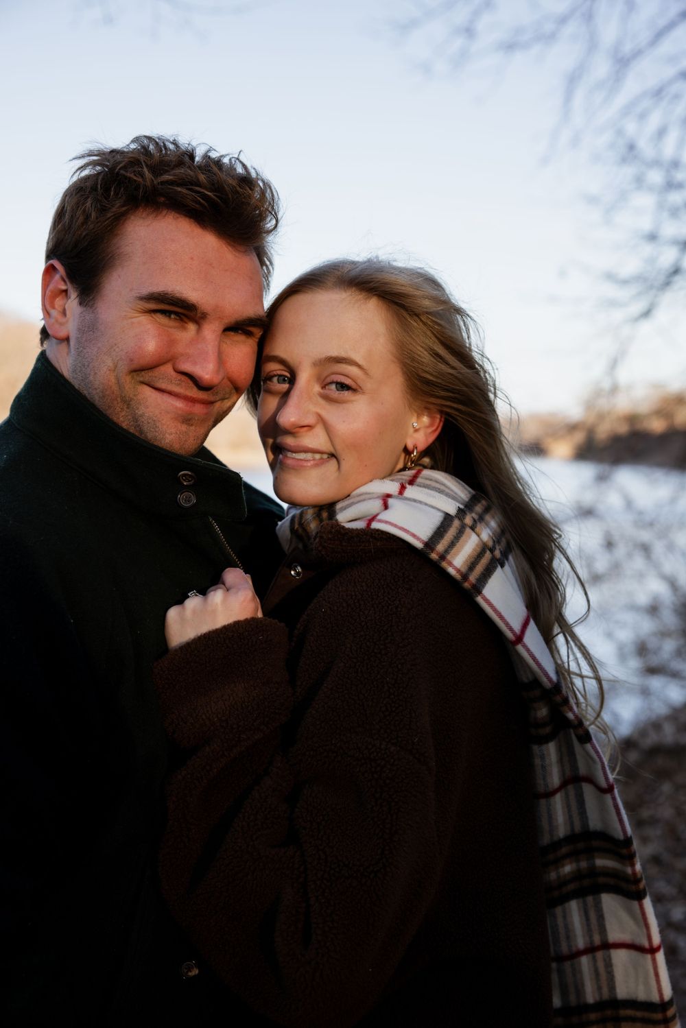 Couple snuggled up by river