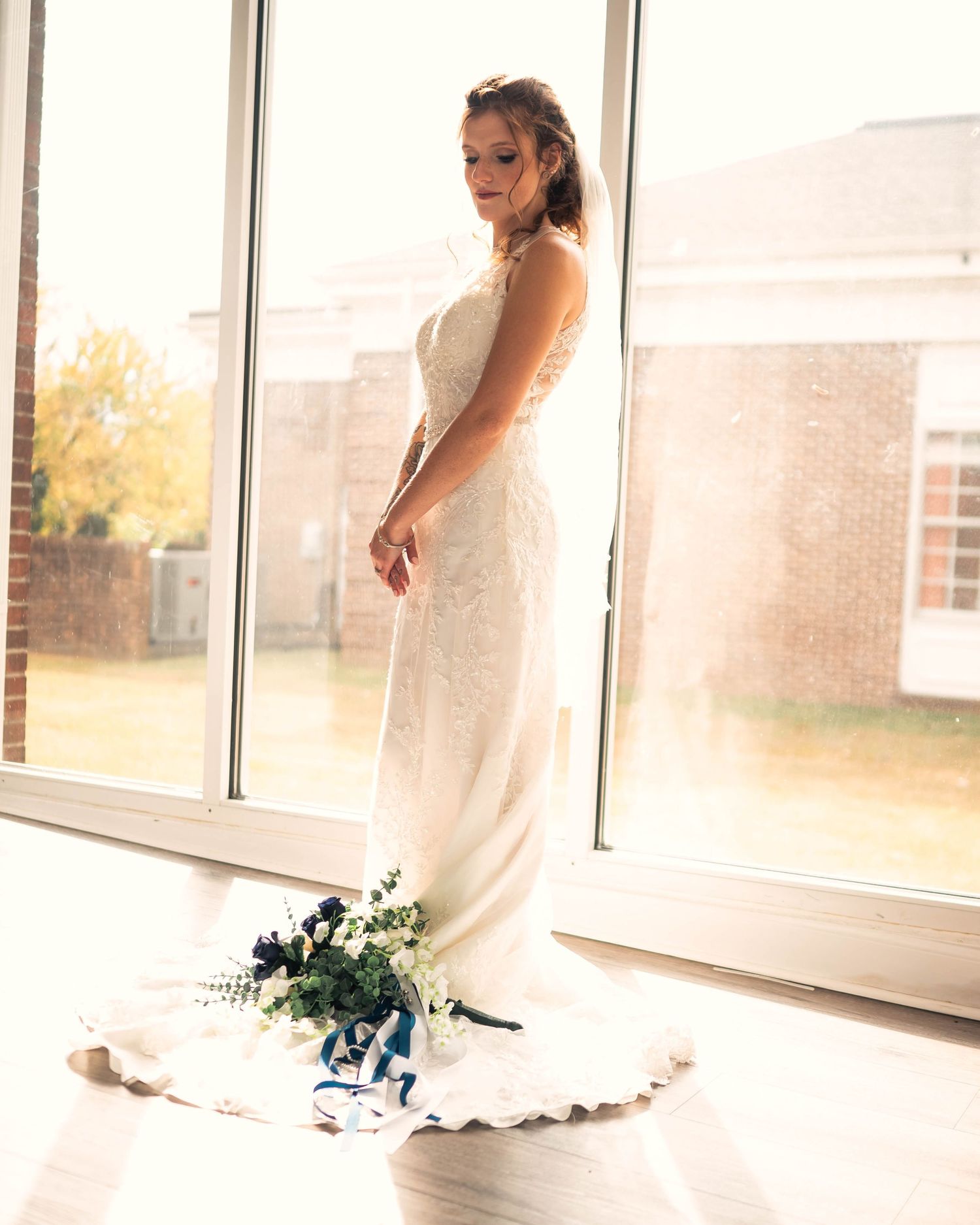 Elegant bridal portraits taken in a bright, window-lit room showing the full wedding dress.