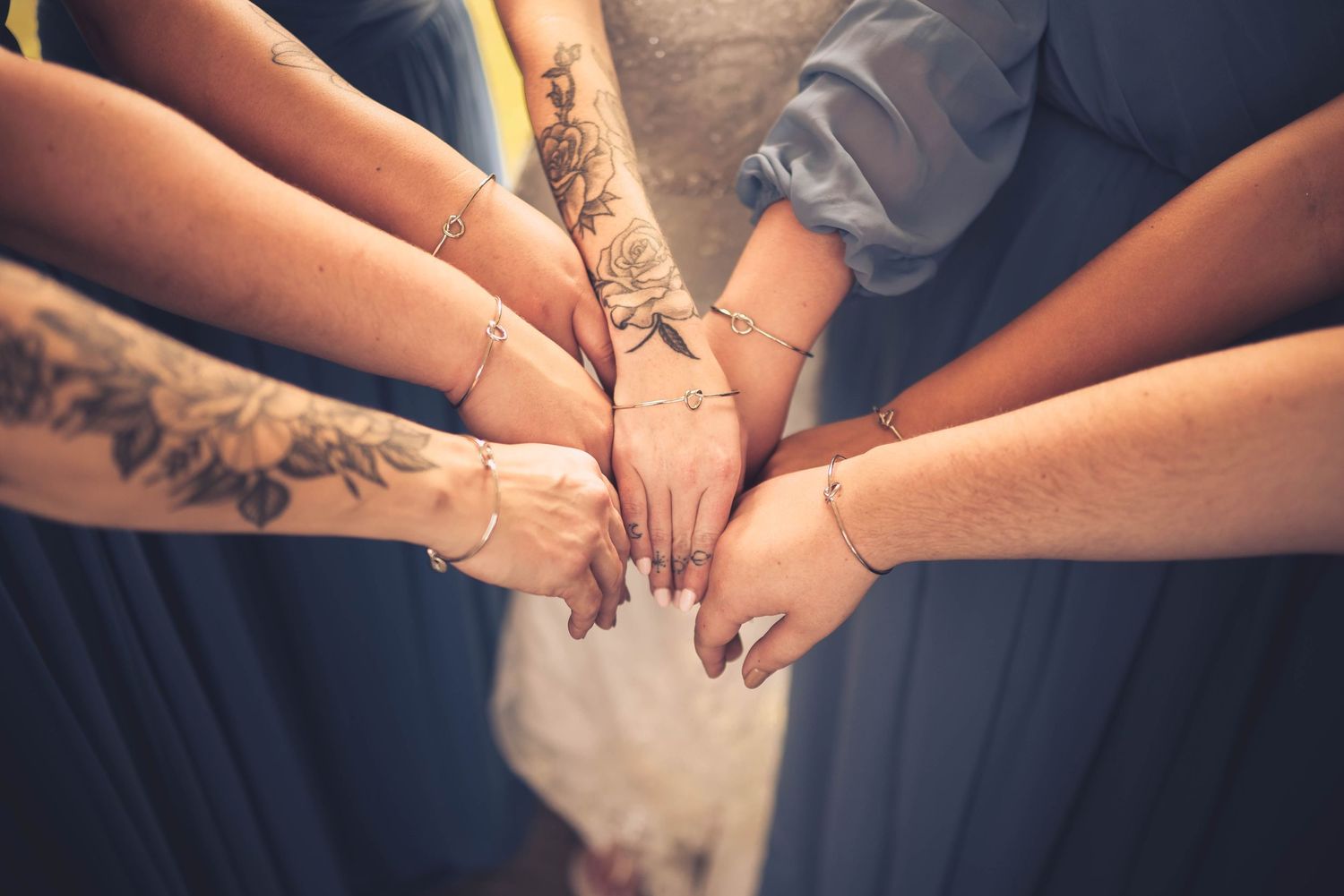 Close-up of hands joined together in unity, wearing formal attire.