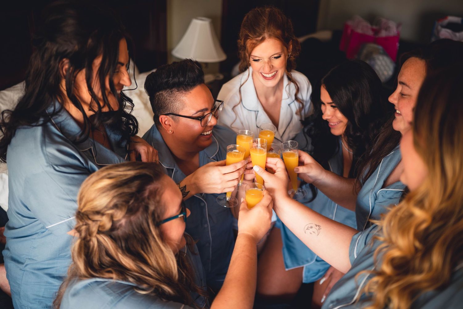 Wedding party enjoying candid celebratory moments together indoors.