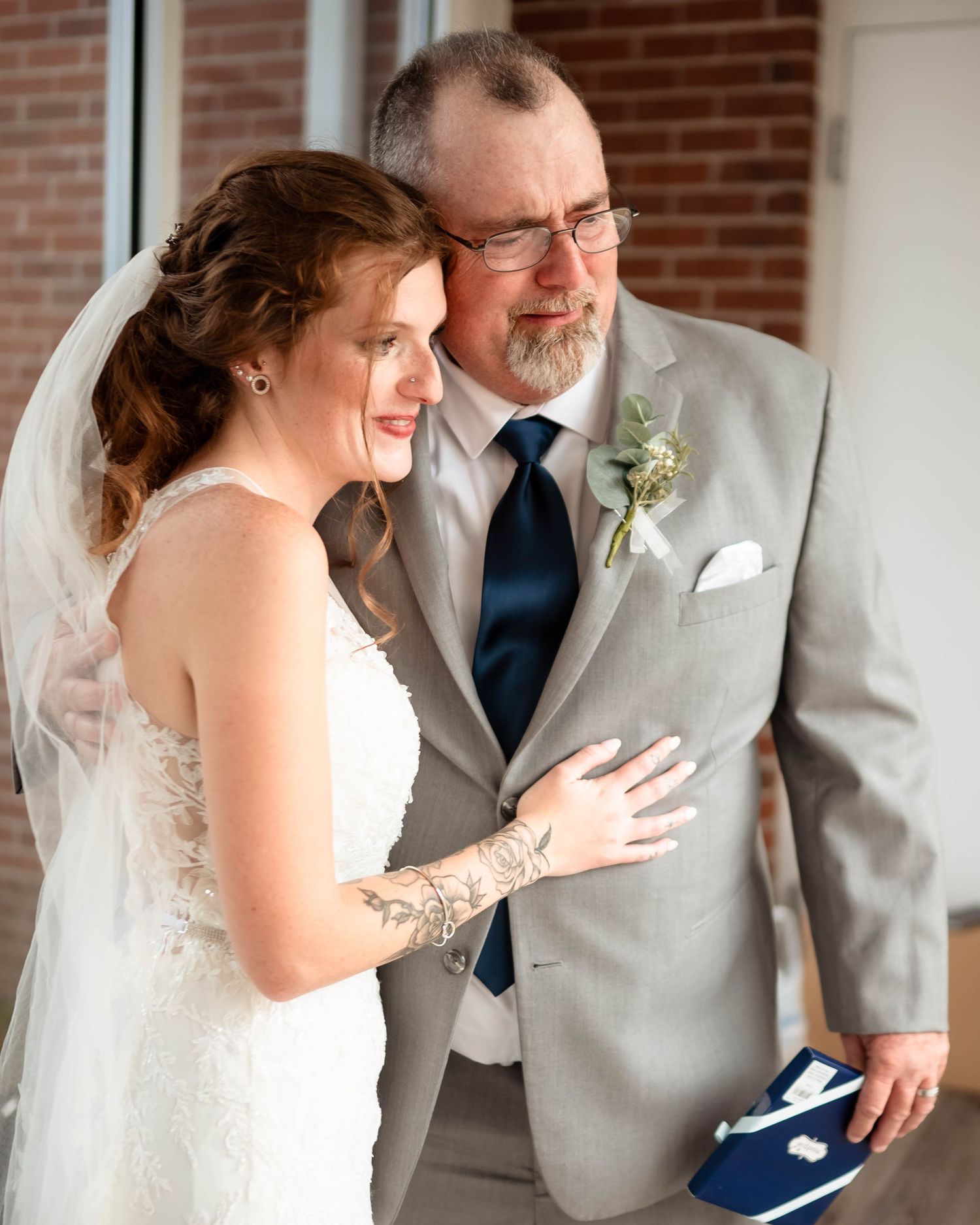 Candid moment between couple in wedding attire showing emotional reactions.