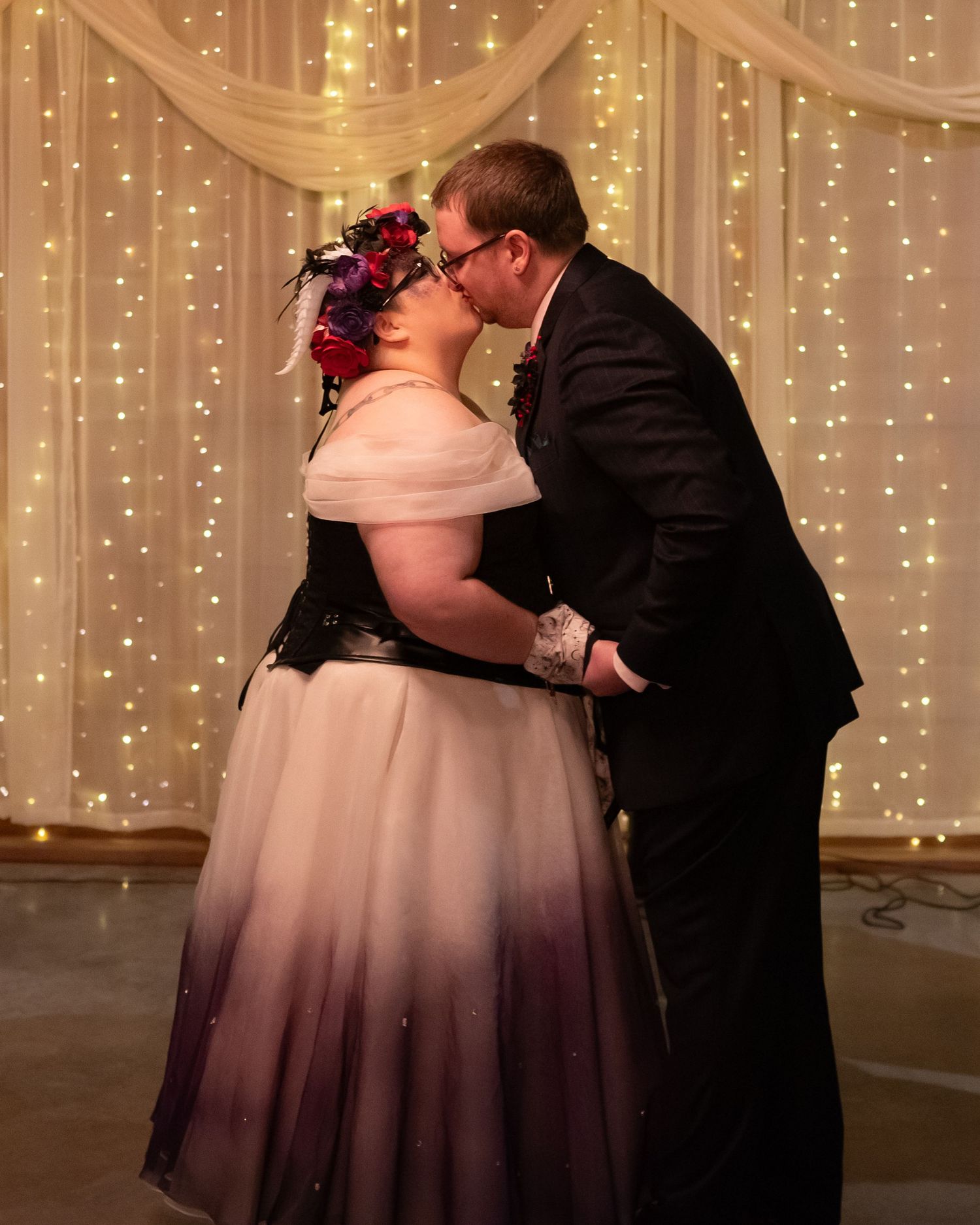 Romantic first dance at wedding reception with twinkle light backdrop and elegant decor.