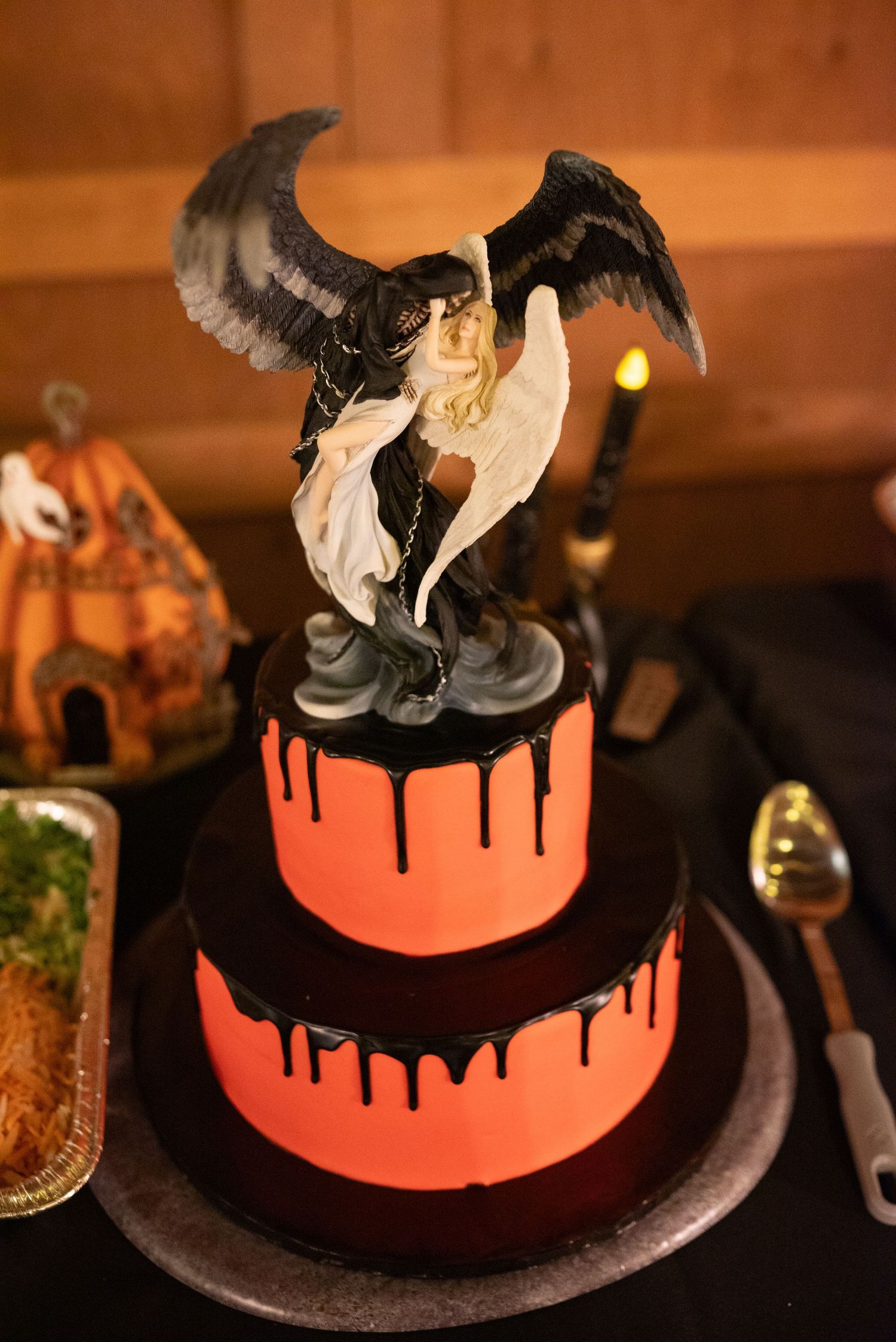 Halloween themed wedding cake with orange glow and dramatic black drip effect.