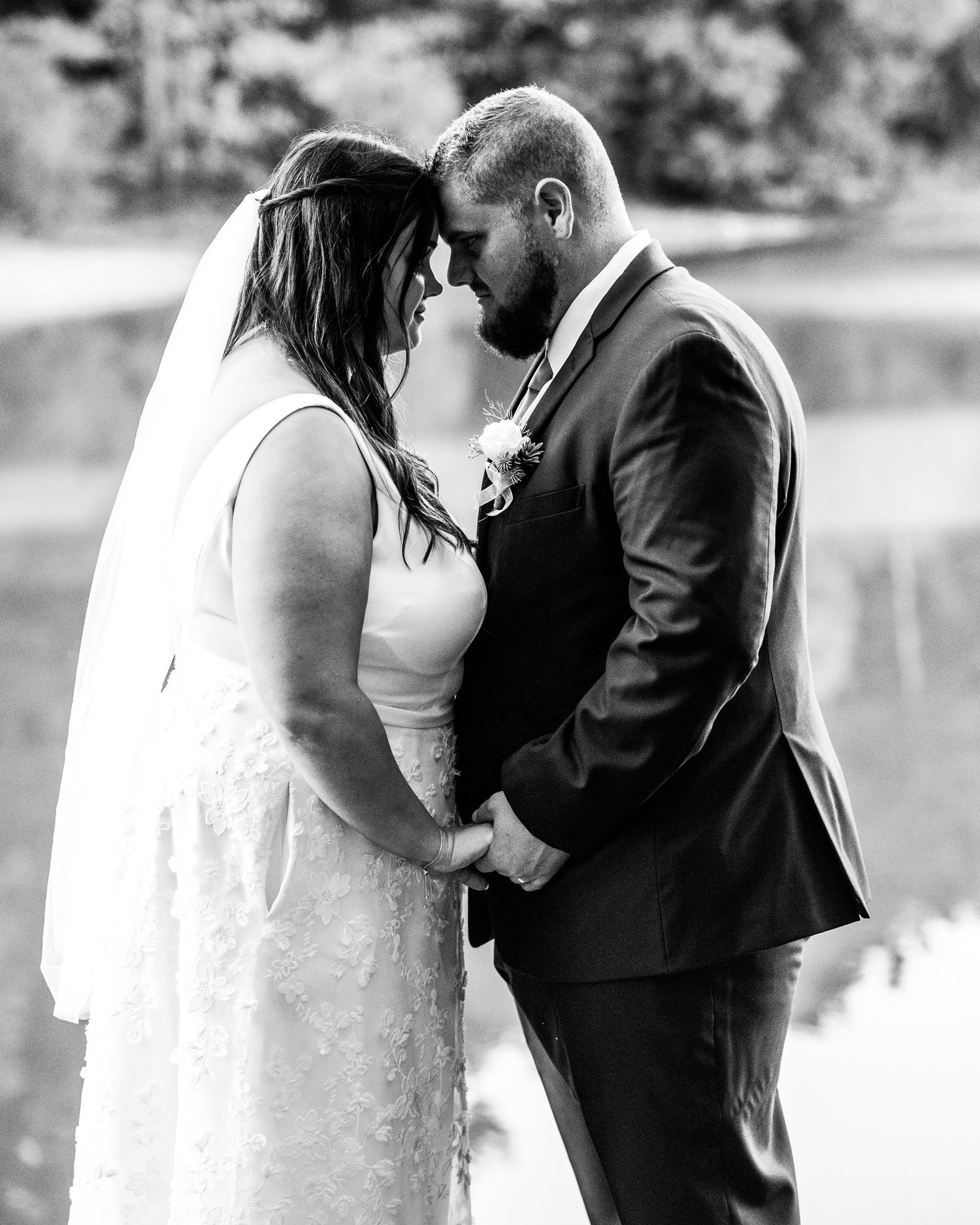 Black and white romantic wedding portrait showing tender moment between newlyweds.