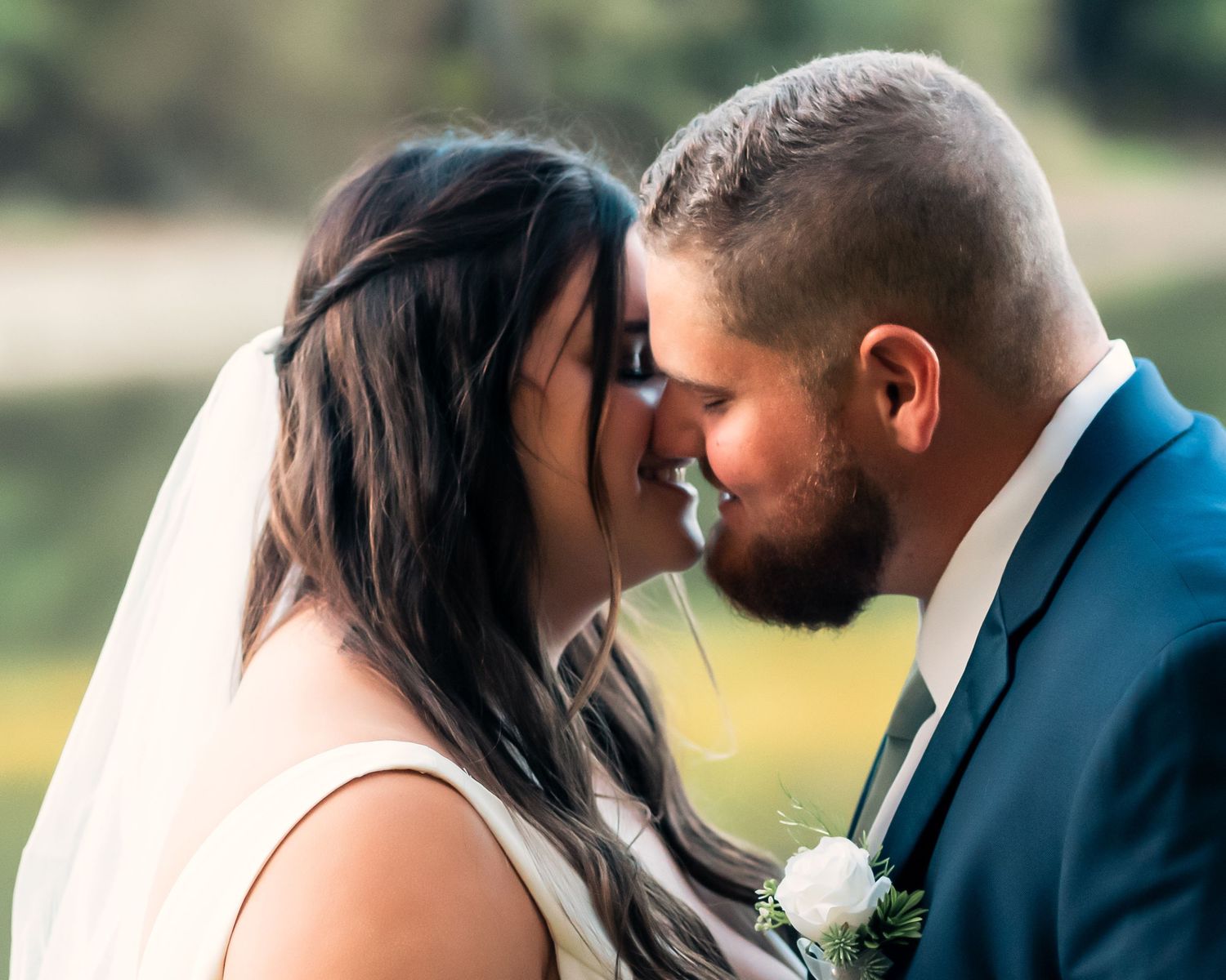 Intimate wedding couple portrait captured in golden outdoor lighting.