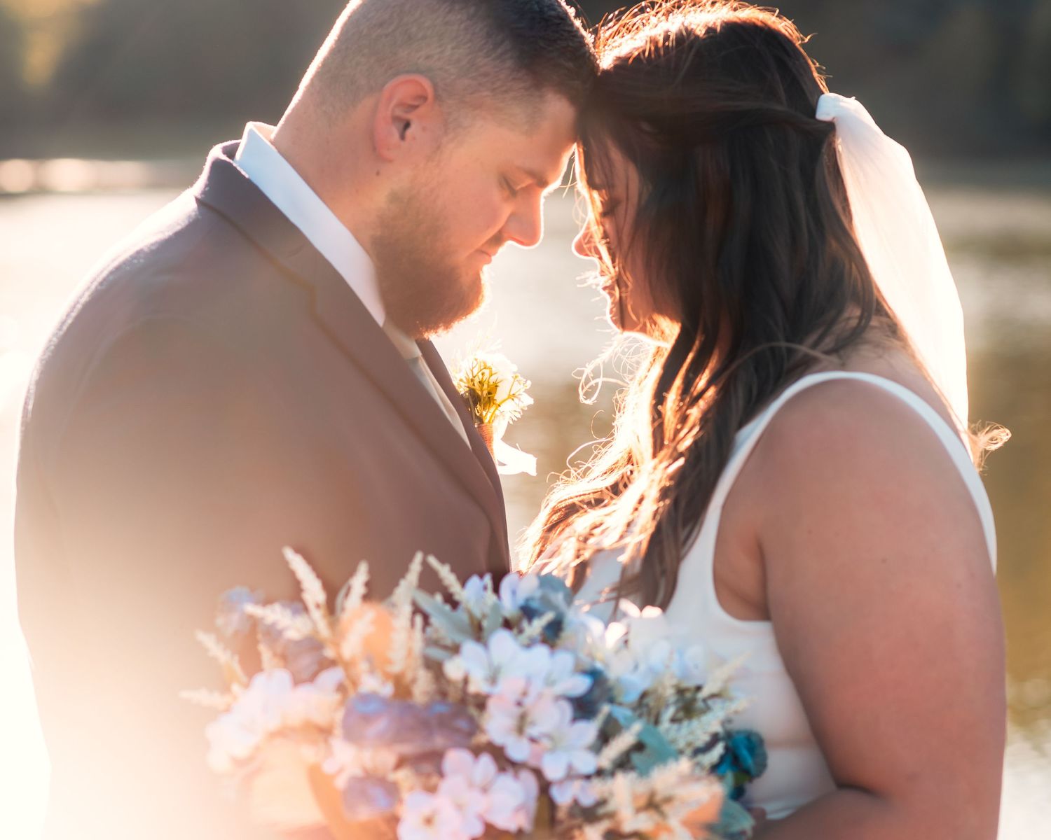Intimate wedding portraits captured during sunset with soft golden lighting.