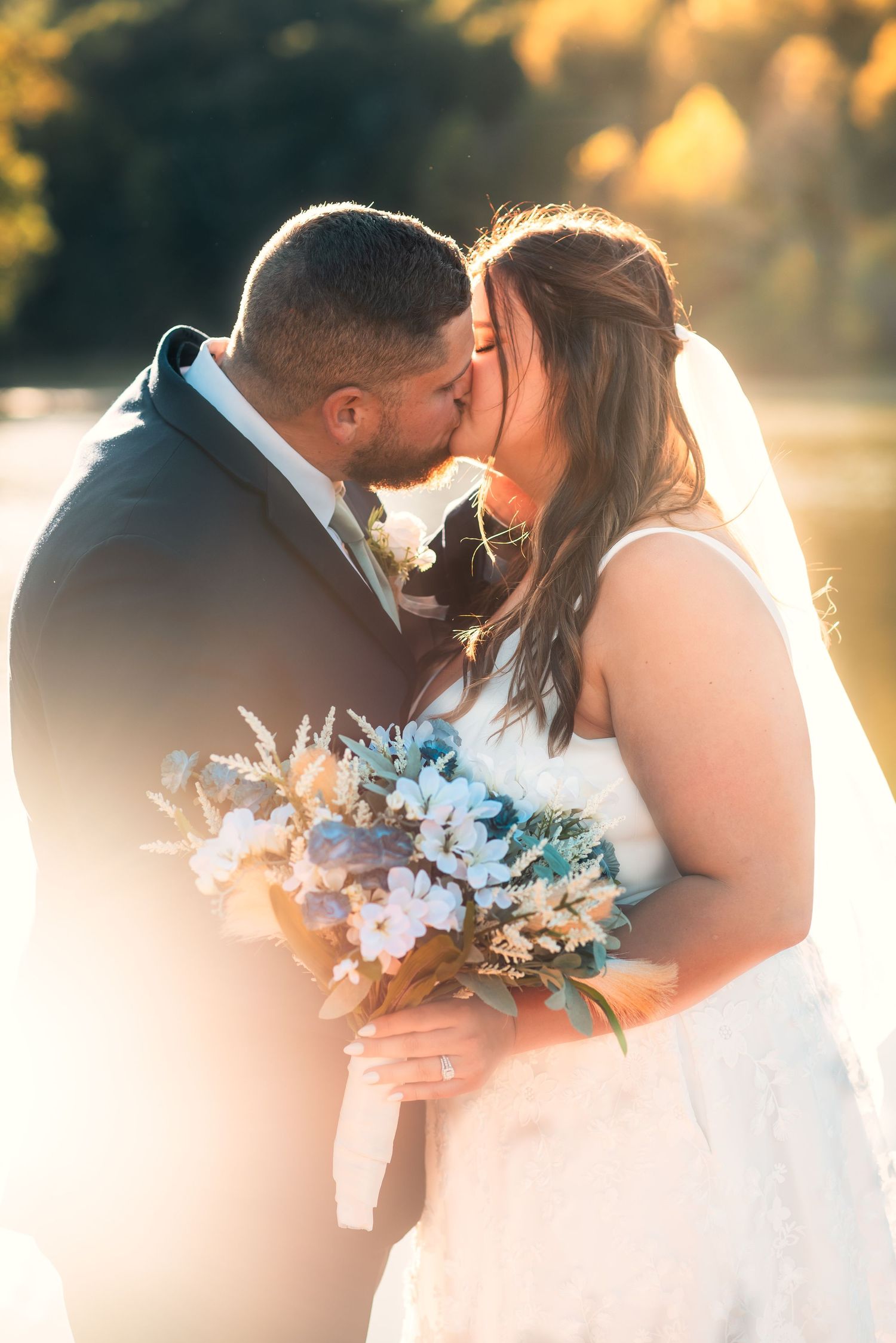 Romantic sunset wedding portraits with turquoise floral bouquet details.