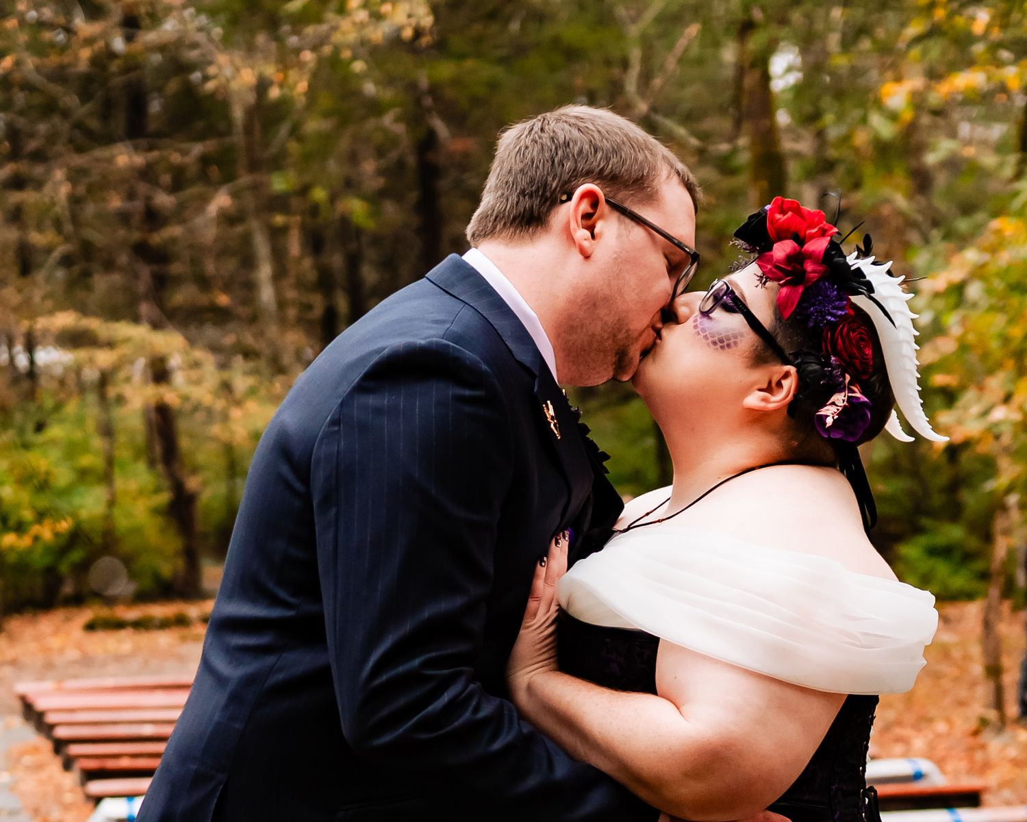 Wedding couple shares romantic moments in an autumn park setting.