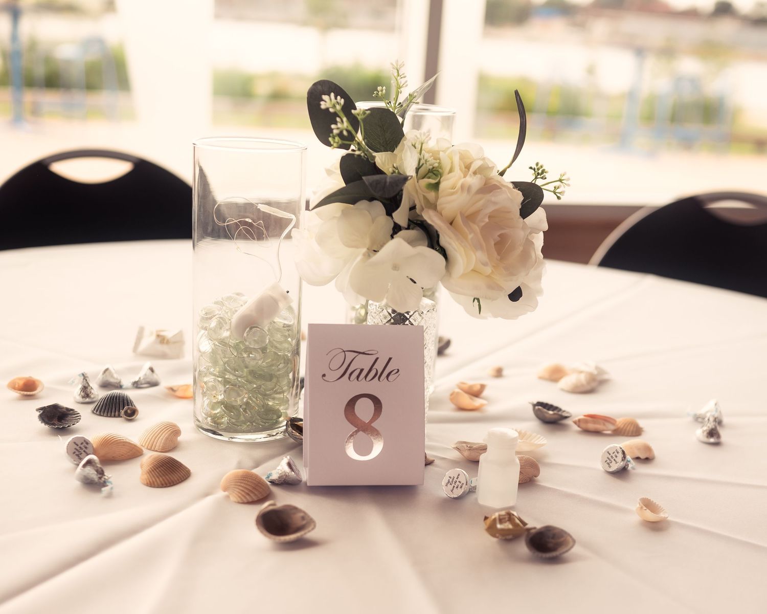 Elegant wedding reception table settings with delicate floral centerpieces and place cards.