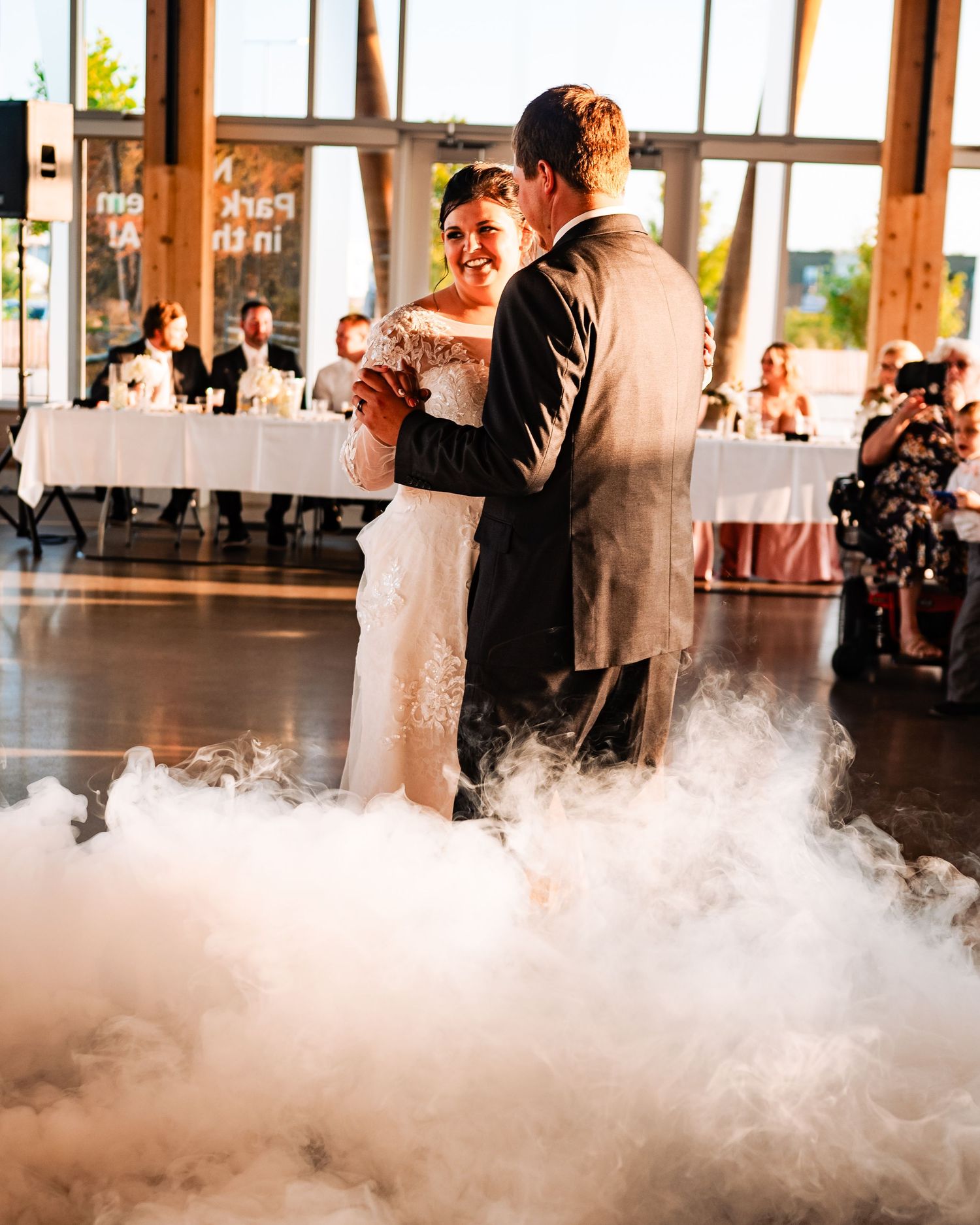 First dance of newlyweds surrounded by dramatic fog effects on the dance floor.