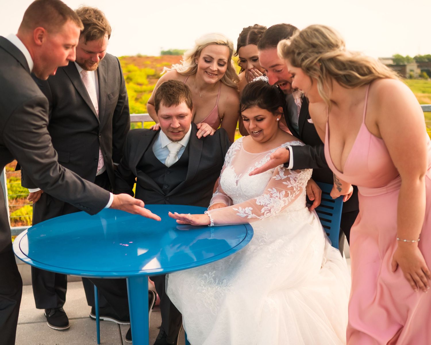 Wedding party gathers around a blue table for a fun group activity.