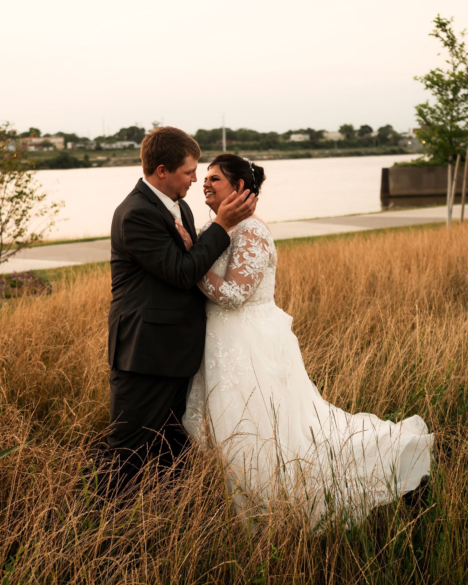 Romantic couple portraits in tall grass field during golden hour wedding photography.