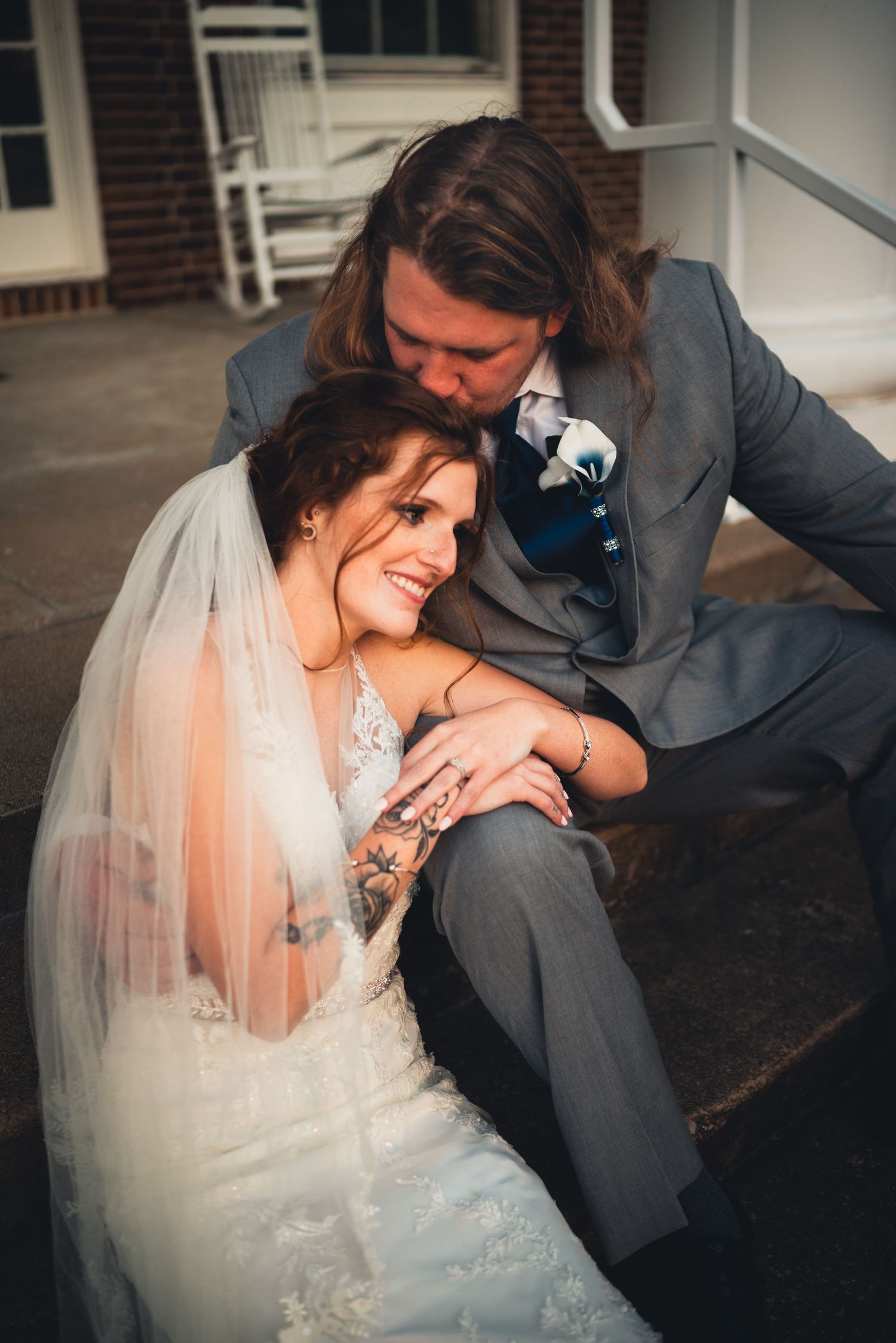 Intimate moment between newlyweds sitting together in formal attire.