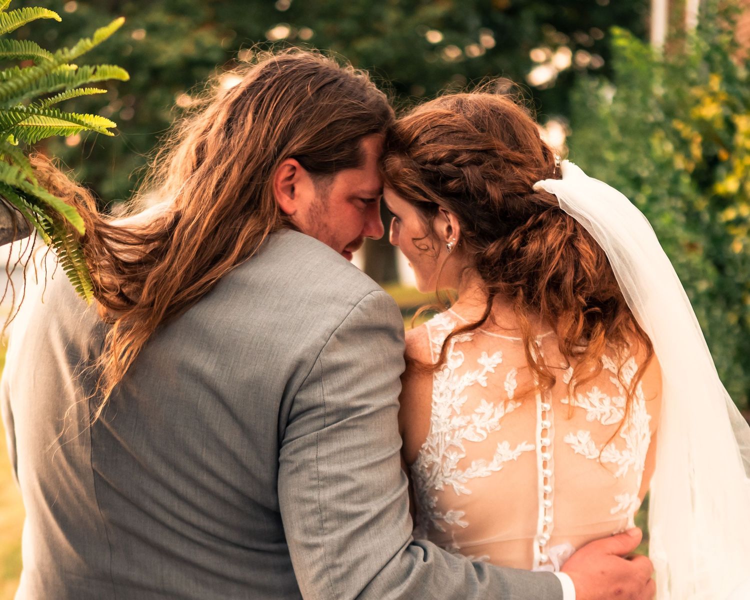 Romantic outdoor portrait of newlyweds sharing a tender moment.