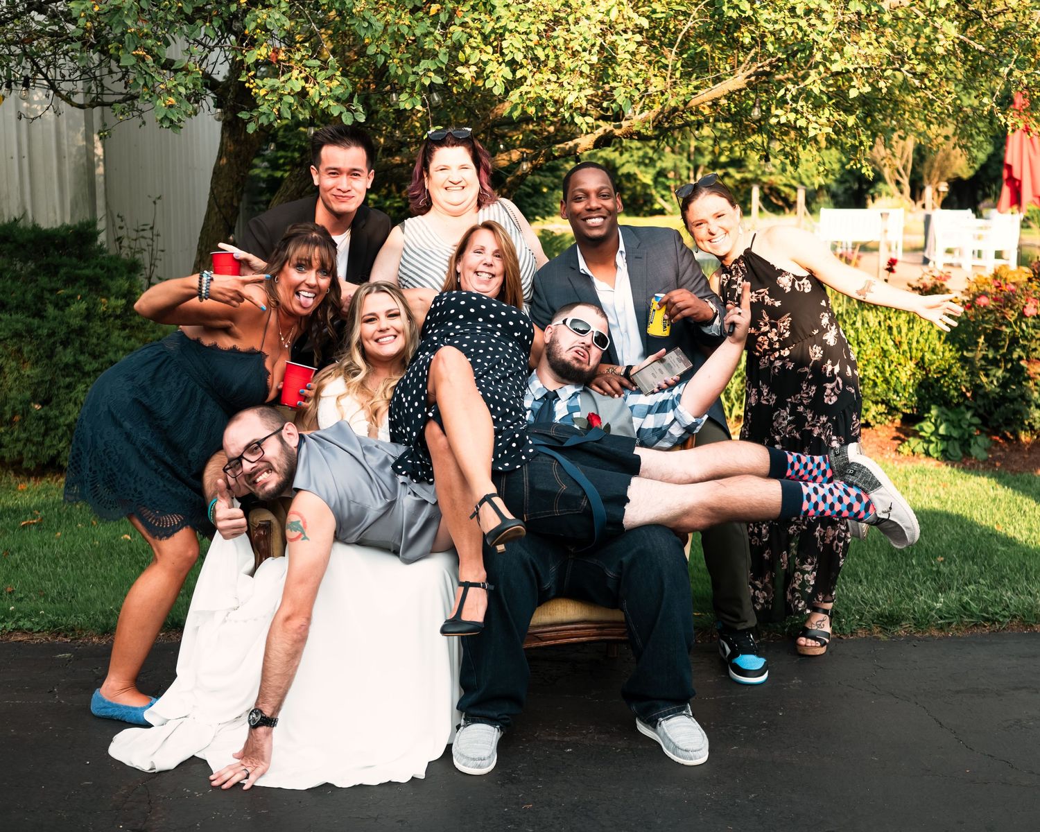 Wedding guests relax on a grassy lawn during an outdoor celebration.