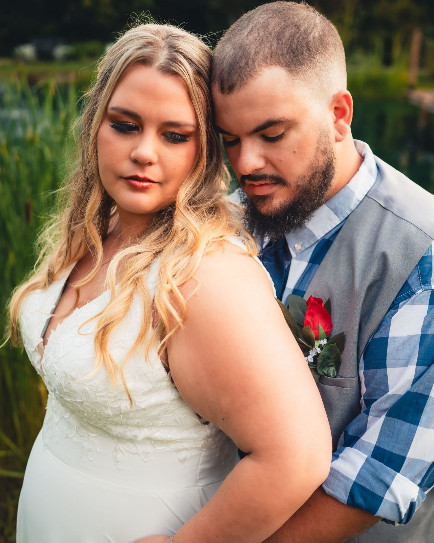 A romantic wedding portrait shows a couple embracing in an outdoor garden setting.