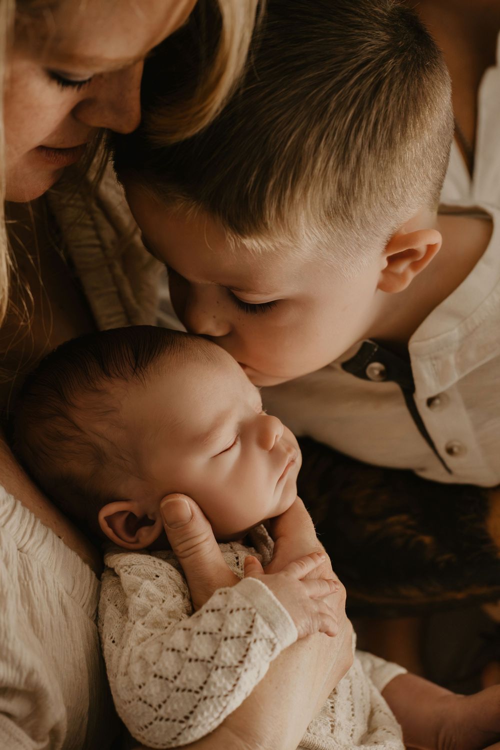Intimate family portrait sequence showing tender moments between parent and child in warm sepia tones.