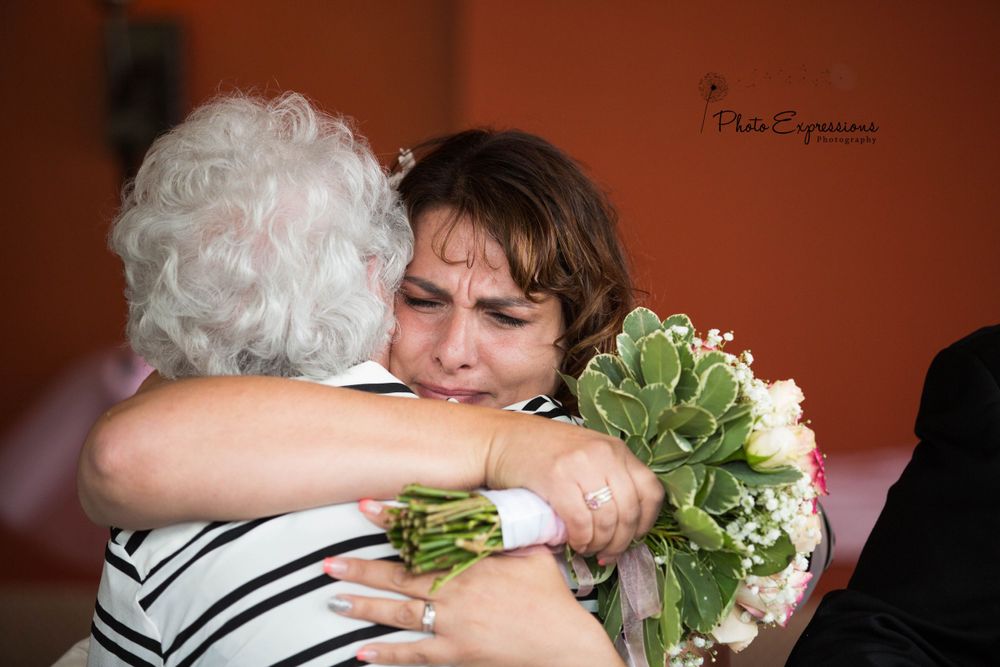 Wedding guests embrace during an emotional moment at the reception.