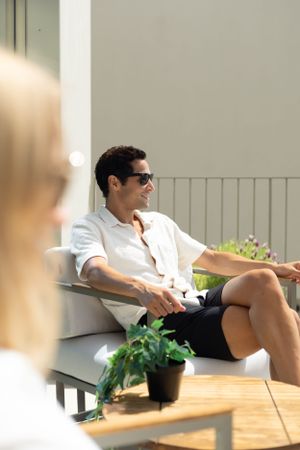 Casual outdoor seating area with lounge chairs and potted plants in natural lighting.