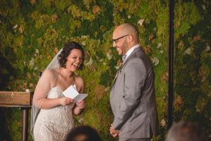 Emotional wedding ceremony moment under green foliage with rustic outdoor decor.