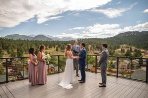 Mountain vista wedding ceremony on wooden deck with stunning views of pine forests.