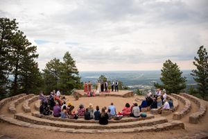 Amphitheater-style wedding ceremony on mountaintop with panoramic views and circular seating arrangement.