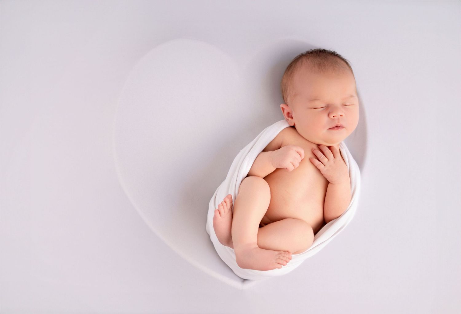 Nyfødtfotograf i Sandnes - Sovende baby i hjertebolle på nyfødtfotografering i studio