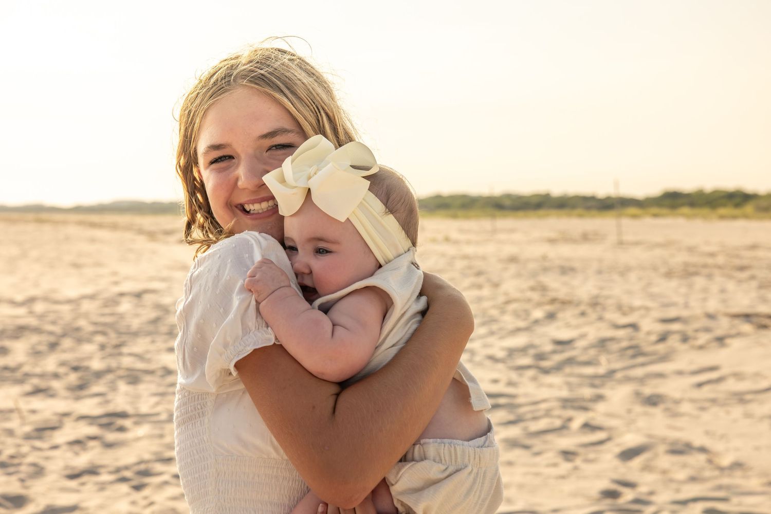 Tender embraces shared on a sandy beach during golden hour.