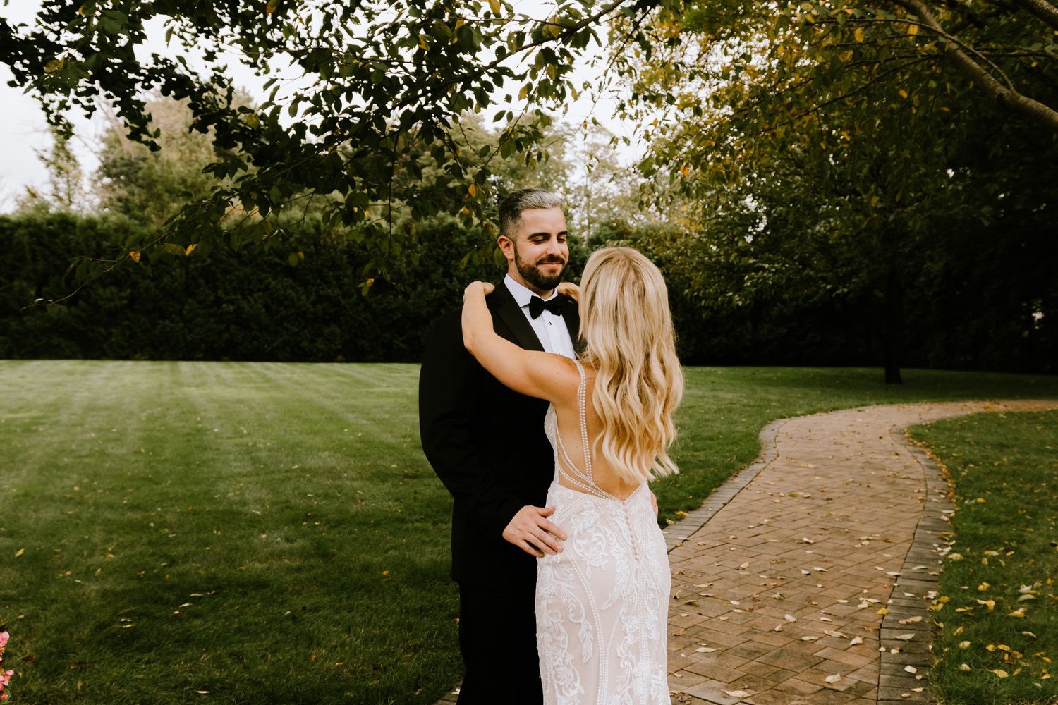 Newlyweds sharing intimate moment in garden setting.