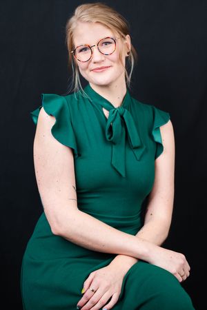 Professional portrait series showing someone in an emerald green dress against a dark background posing in different positions.