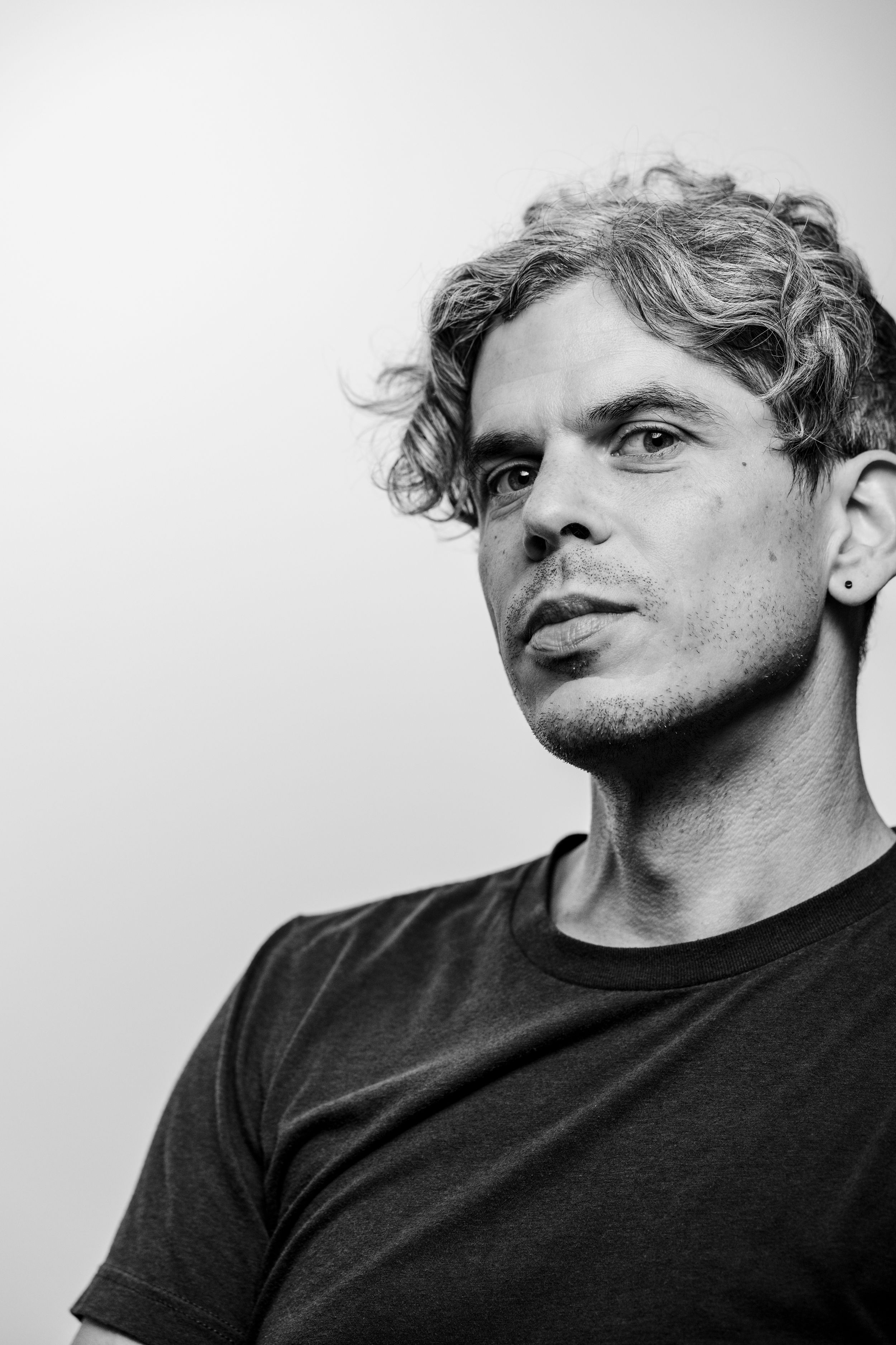 Black and white artistic portrait series showing different angles of a person wearing a dark t-shirt.