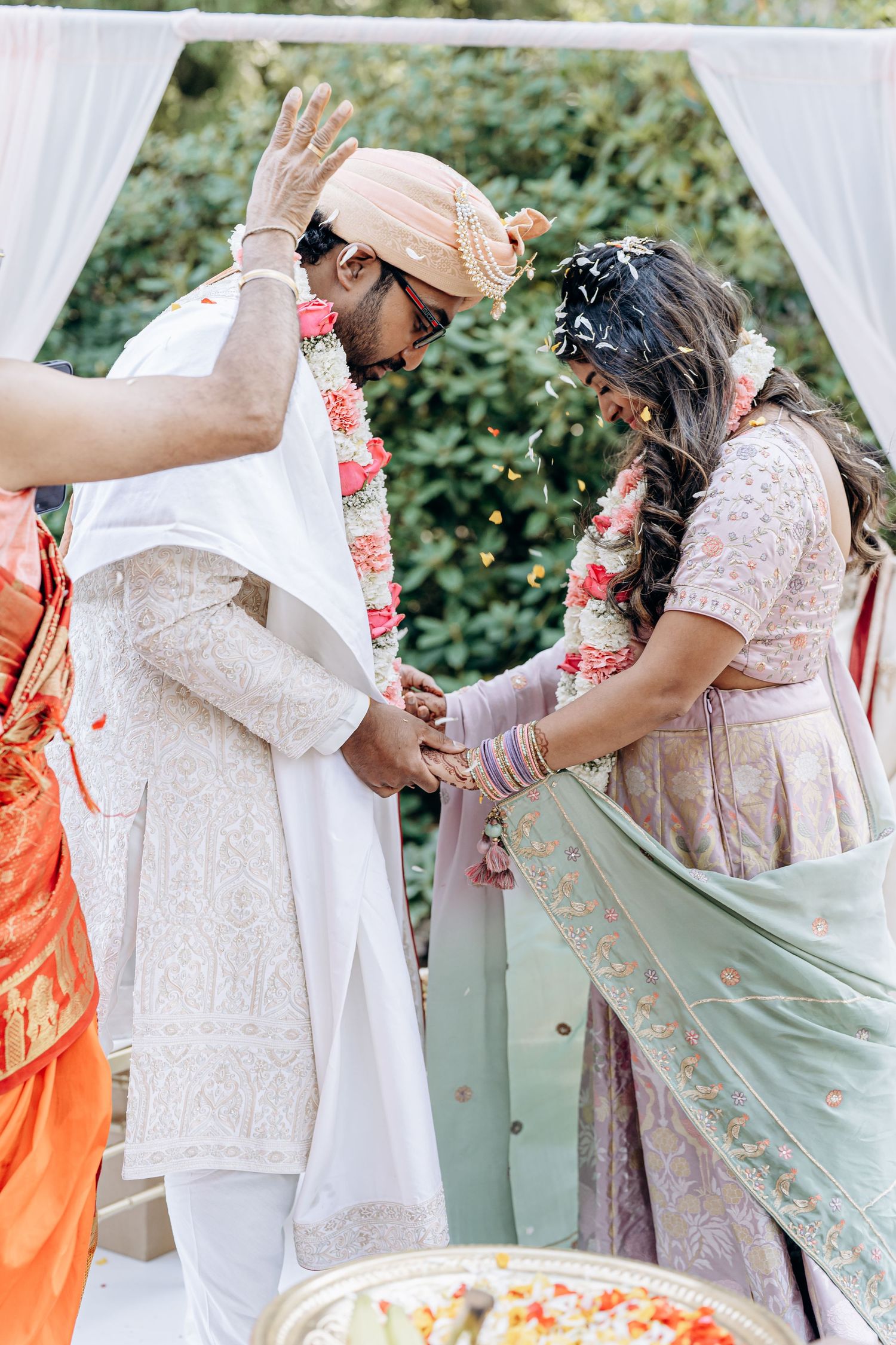 Wedding party in traditional Indian attire with white and mint green colors during outdoor celebration.