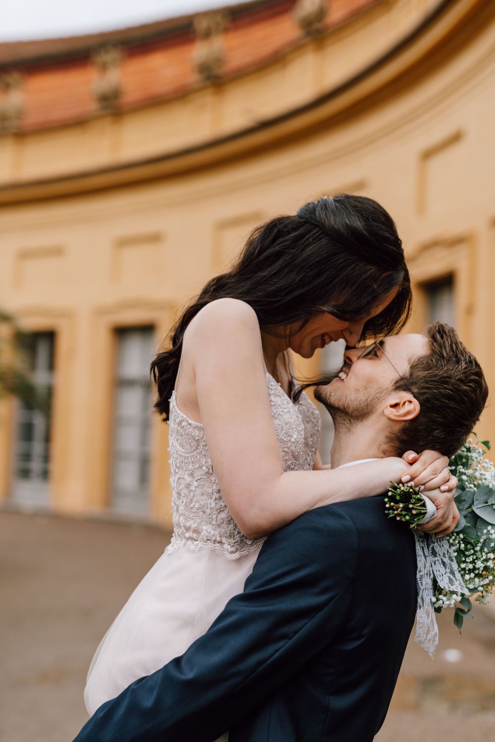A romantic kiss captured against warm-toned historic architecture.